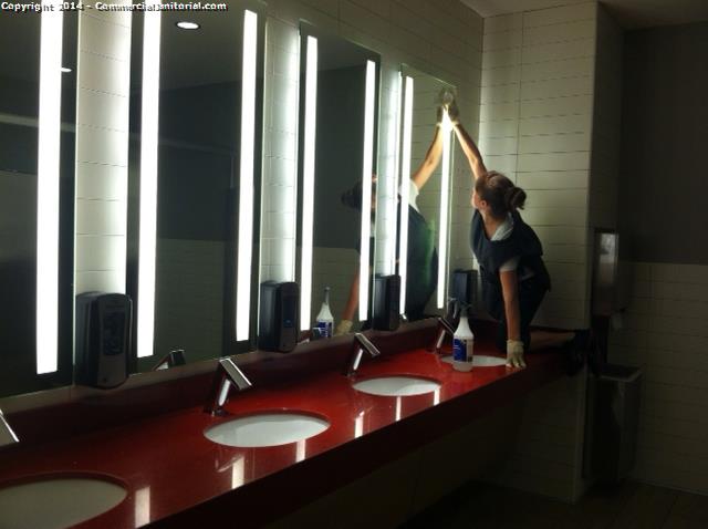 Cleaners getting up high to wipe mirrors. smudges free. 