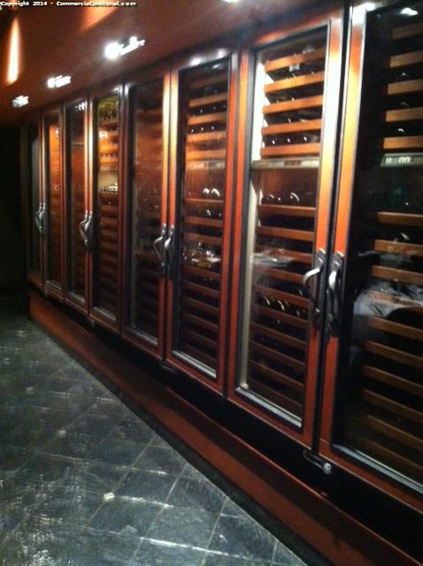 Cleaning the interior and exterior glass on wine racks in a restaurant