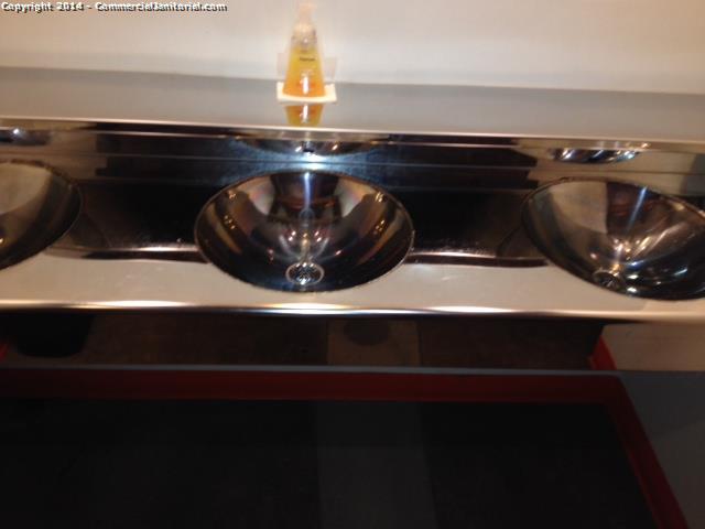 Cleaned and shined washbasins in restroom. Soap dispenser is filled.