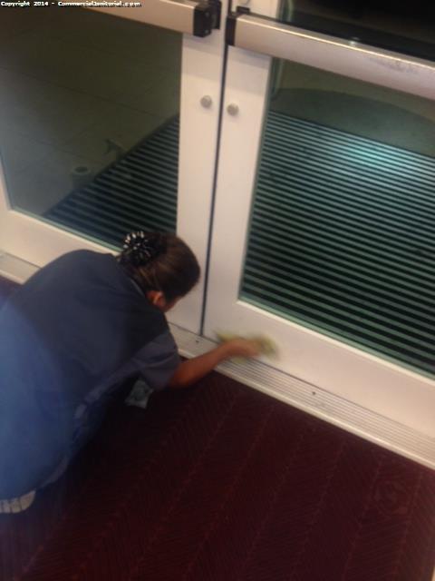 Look at the janitors detail clean the doors as part of an office cleaning service